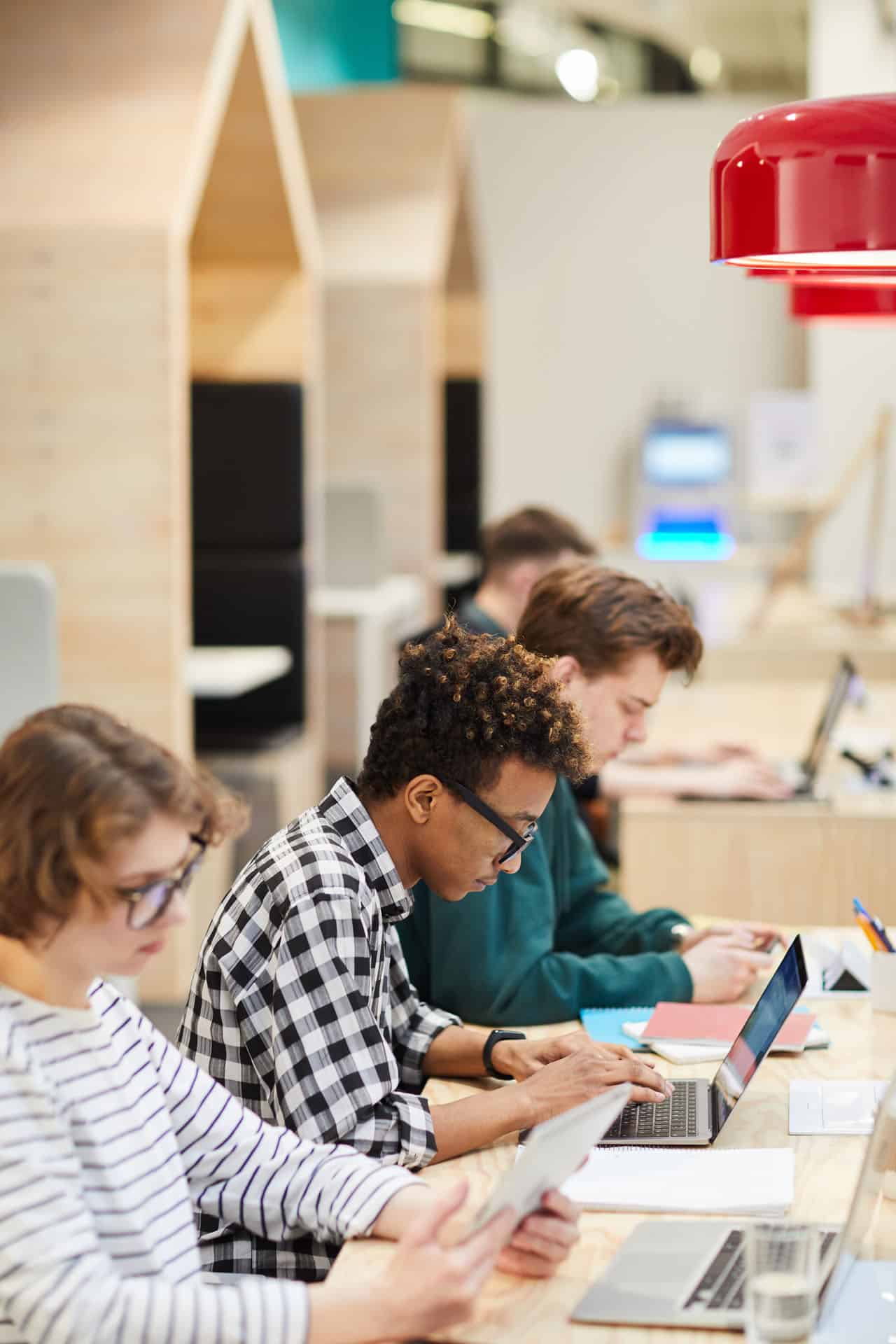 International students studying together on laptops in a modern classroom