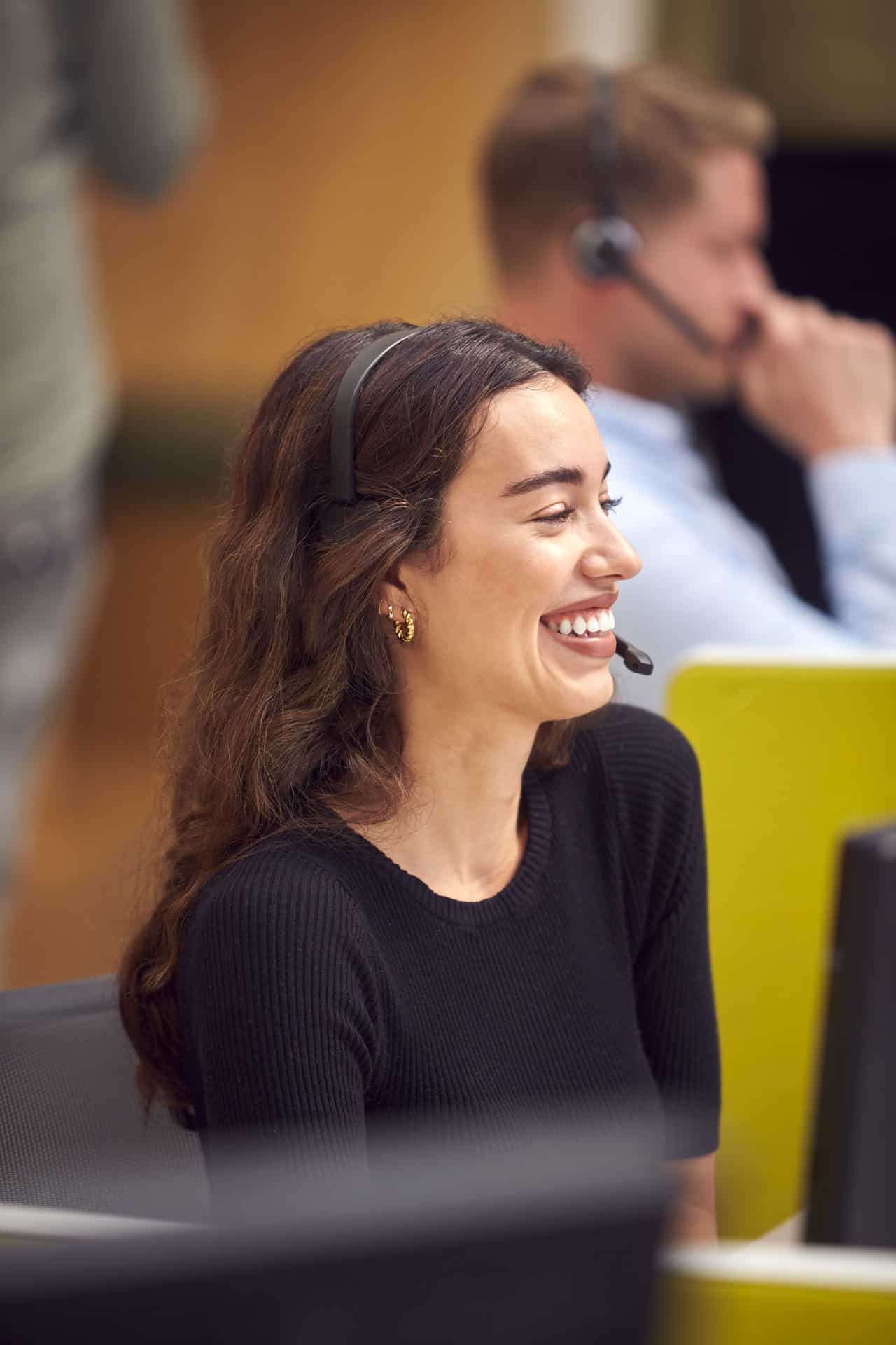 A smiling admissions advisor wearing a headset, ready to assist students with inquiries.