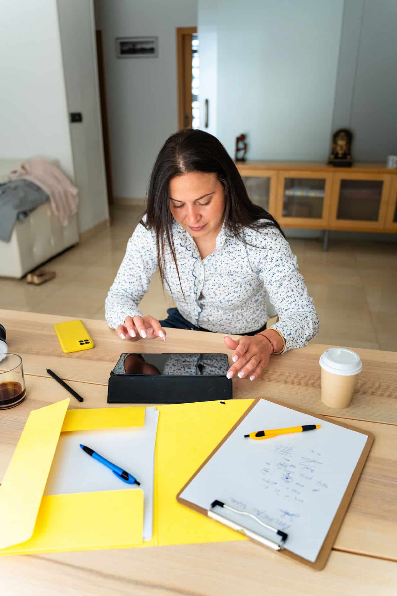 An adult professional reviewing documents on a tablet, preparing for prior learning assessment.